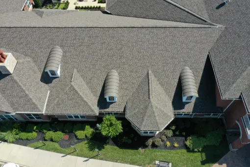 An aerial view of a large house with a gray roof.