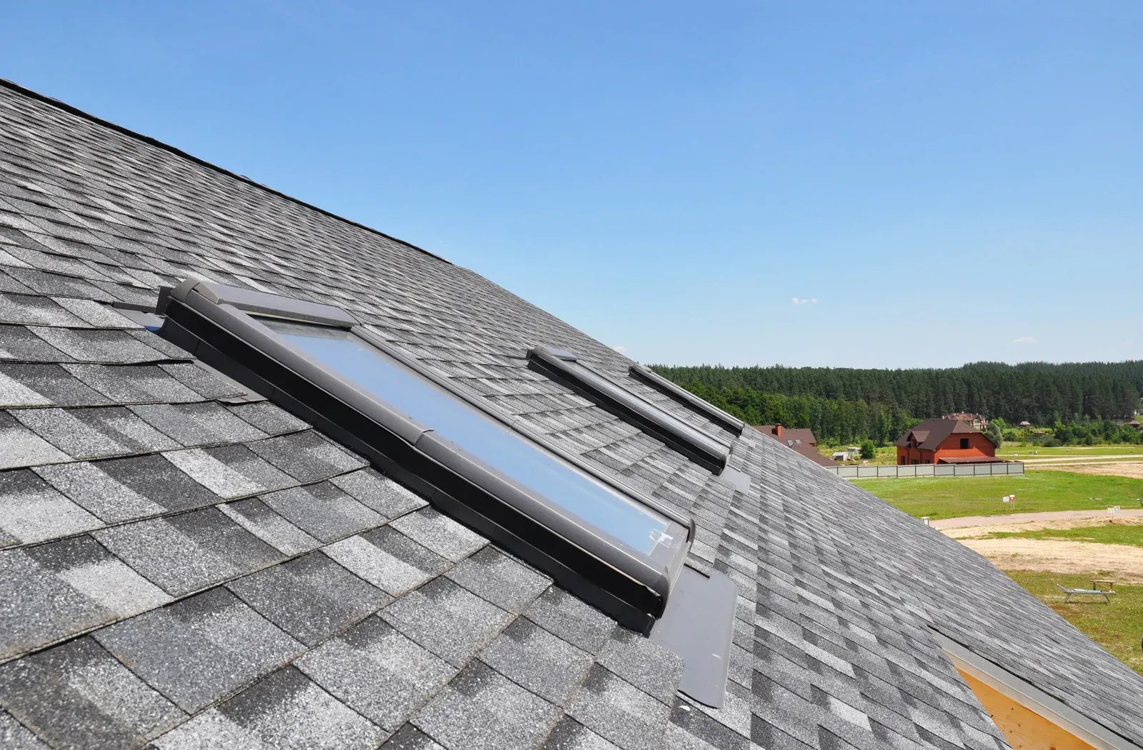 There are two skylights on the roof of a house.
