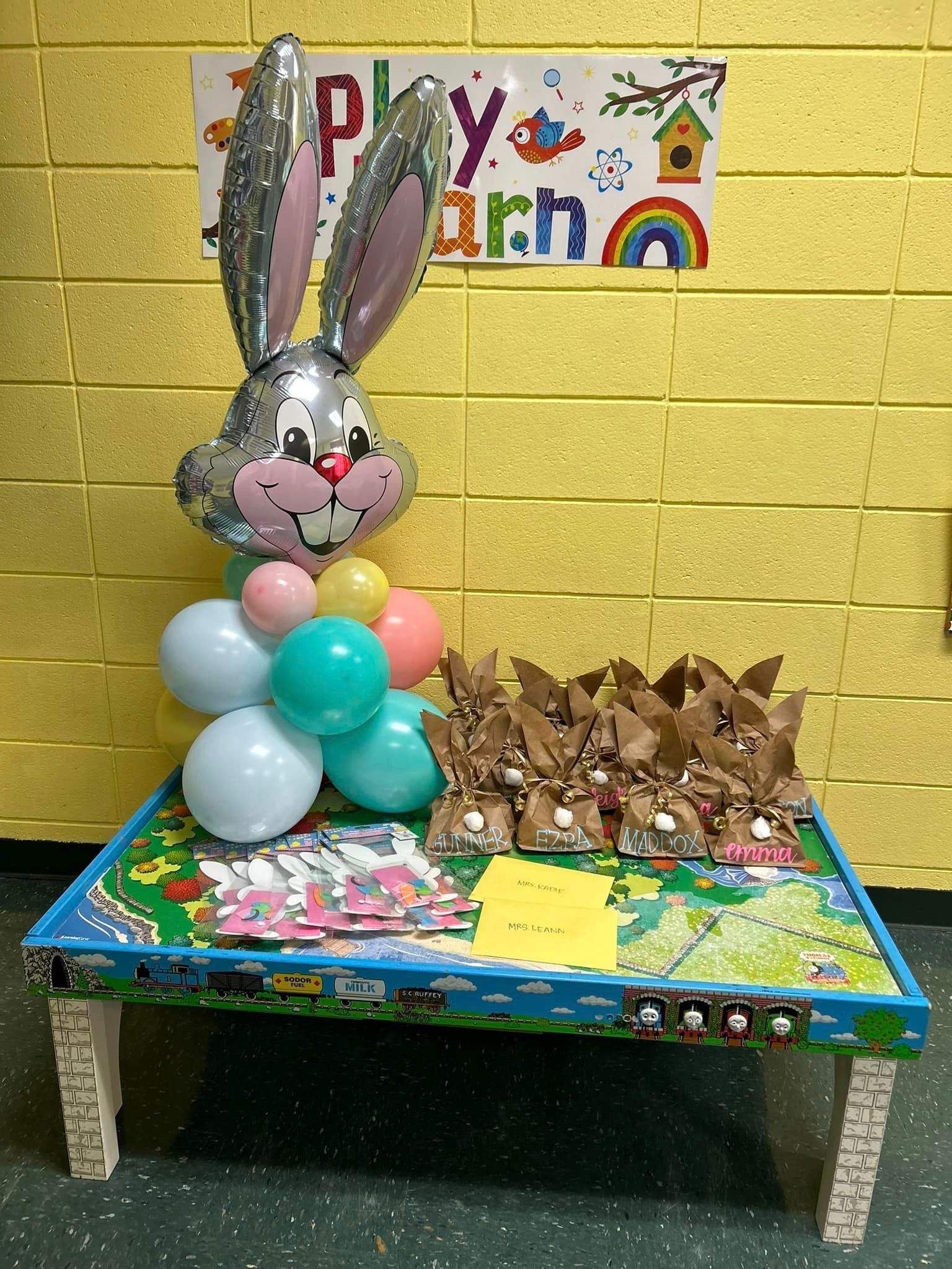 A table with balloons and a bunny balloon on it