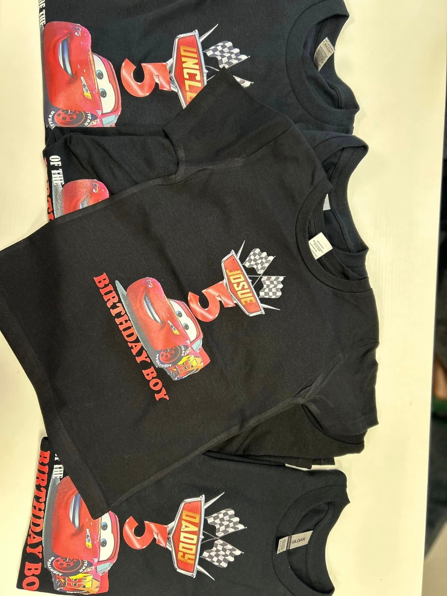 A bunch of black shirts with cars on them