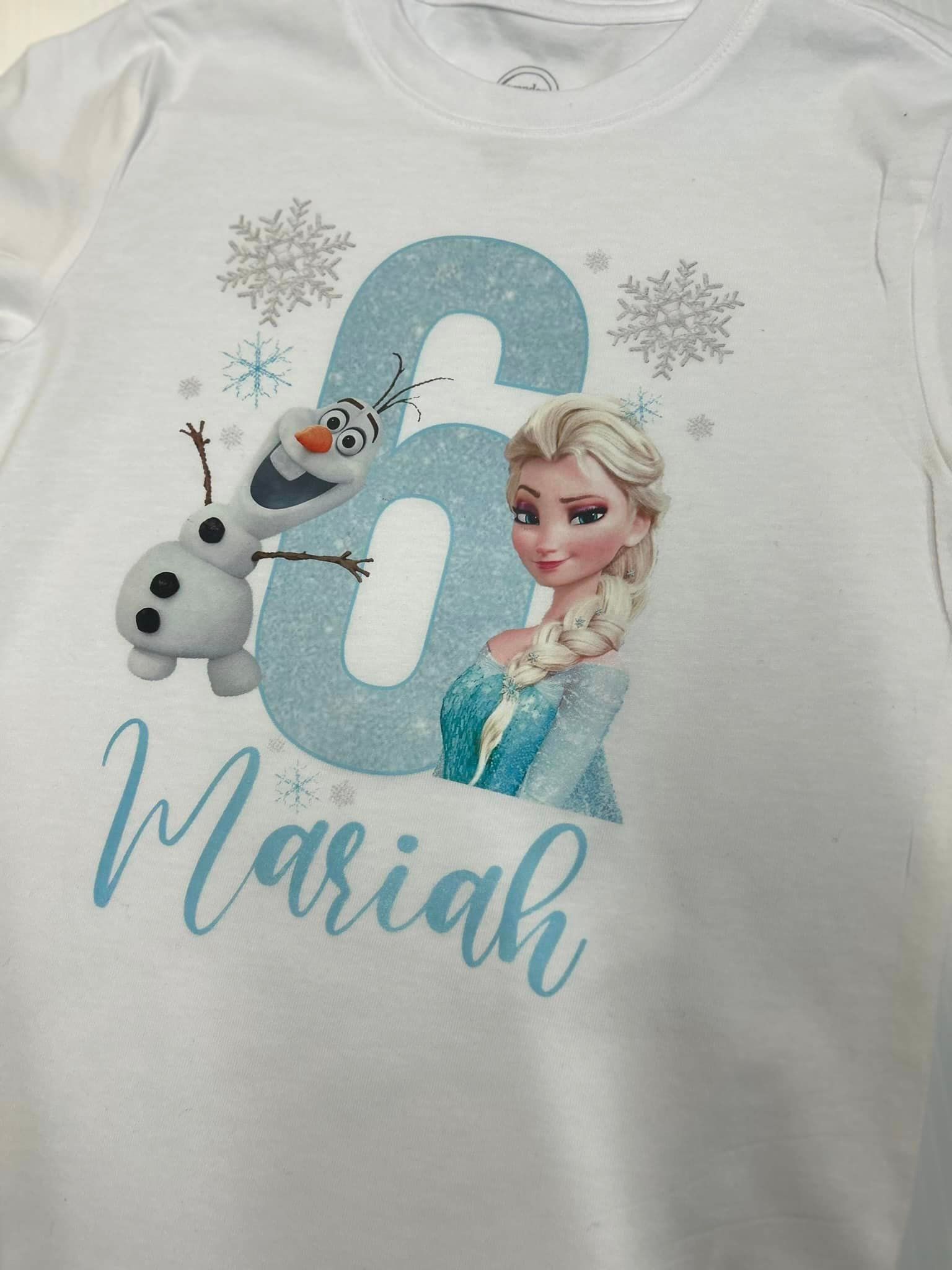 A white t-shirt with a picture of elsa and olaf on it