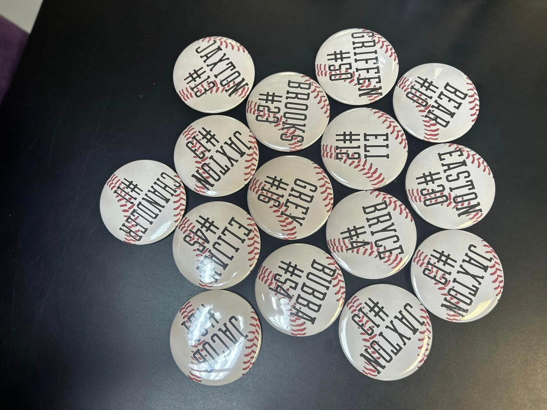 A bunch of baseball buttons with names on them