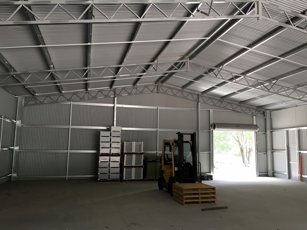 Gray Metal Building With Water Tanks, Set in a Field — Northern Rivers Sheds in South Lismore, NSW