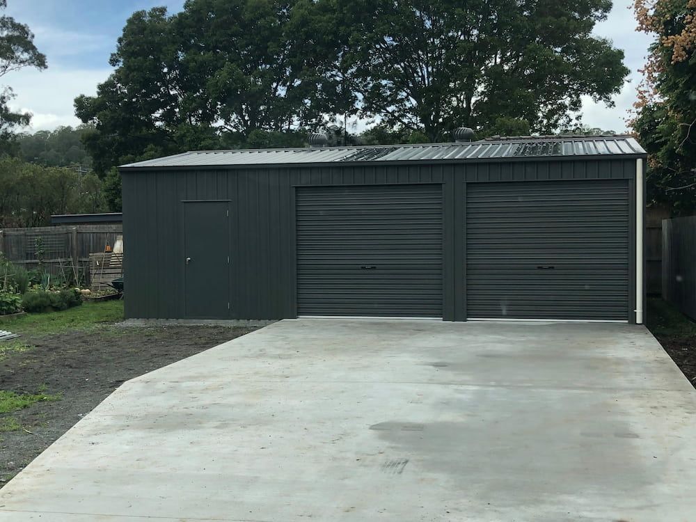 Gray Metal Garage With Two Roll-up Doors, a Side Door — Northern Rivers Sheds in South Lismore, NSW
