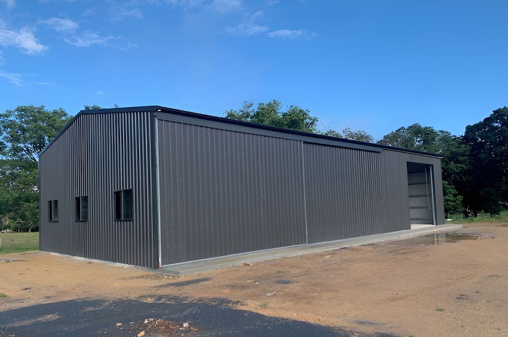Gray Metal Building With a Dark Roof, Open Door, and Two Small Windows — Northern Rivers Sheds in South Lismore, NSW