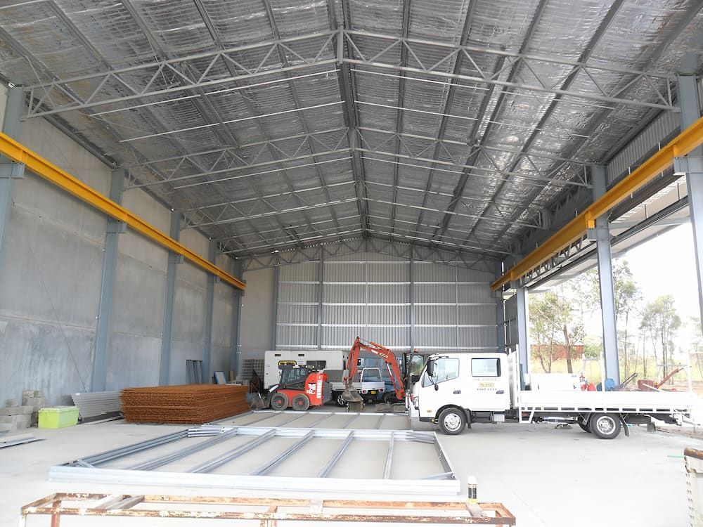 Inside a Large Metal Shed, Construction Vehicles Sit — Northern Rivers Sheds in South Lismore, NSW