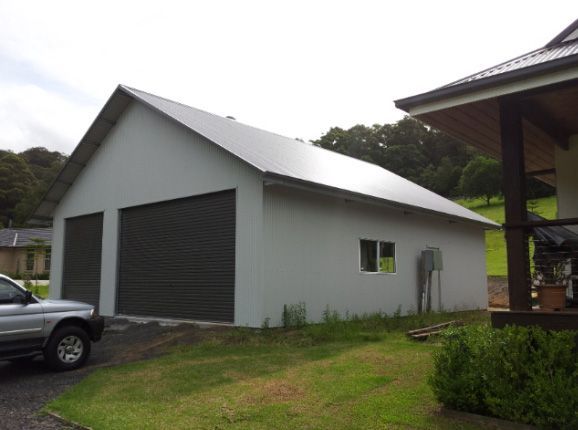 Gray Garage With Two Doors, a Window, and a Silver SUV on a Grassy Lawn — Northern River Sheds in Lismore, NSW