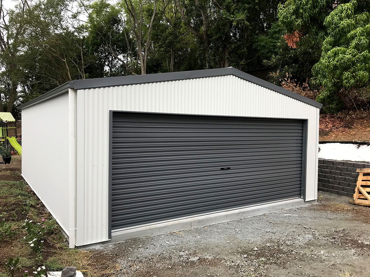 White Shed With Black Roll-up Door, Gravel Ground — Northern River Sheds in Lismore, NSW