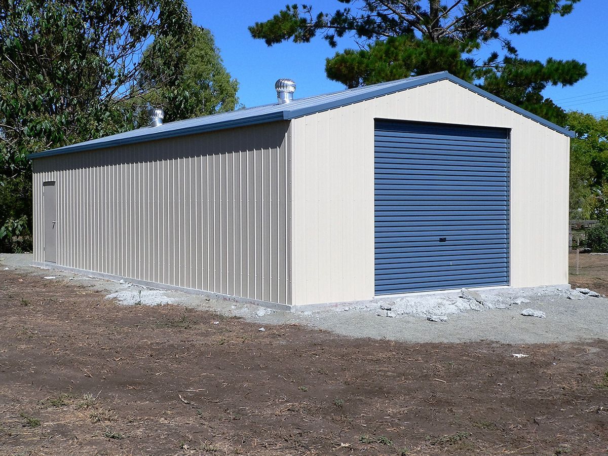 Tan Metal Shed With Blue Garage Door on a Gravel Foundation — Northern River Sheds in Lismore, NSW