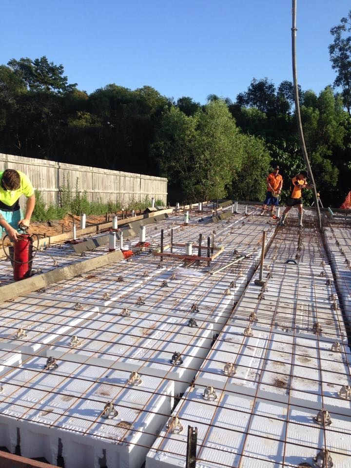 Construction Workers Pouring Concrete Over a Reinforced Structure Outdoors — All Pest QLD In Sippy Downs, QLD