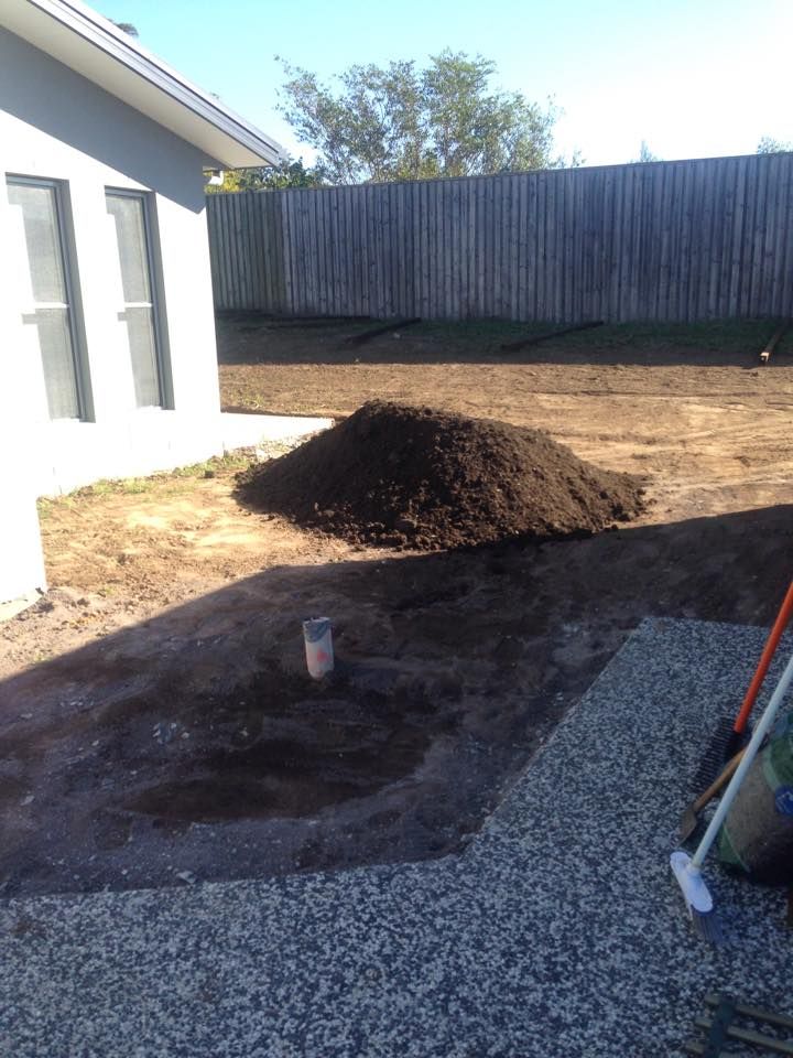 A Backyard With a Pile of Dark Soil a Concrete Patio and a Wooden Fence — All Pest QLD In Sippy Downs, QLD