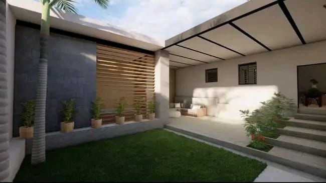 Un patio moderno con césped, una terraza cubierta con asientos, detalles de listones de madera y plantas en macetas.