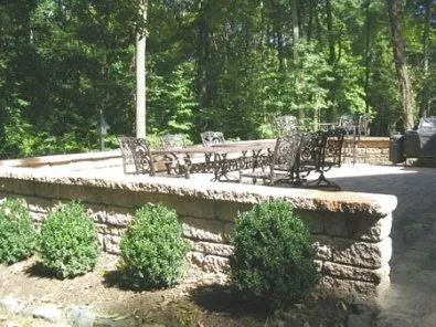 A patio with a table and chairs surrounded by trees