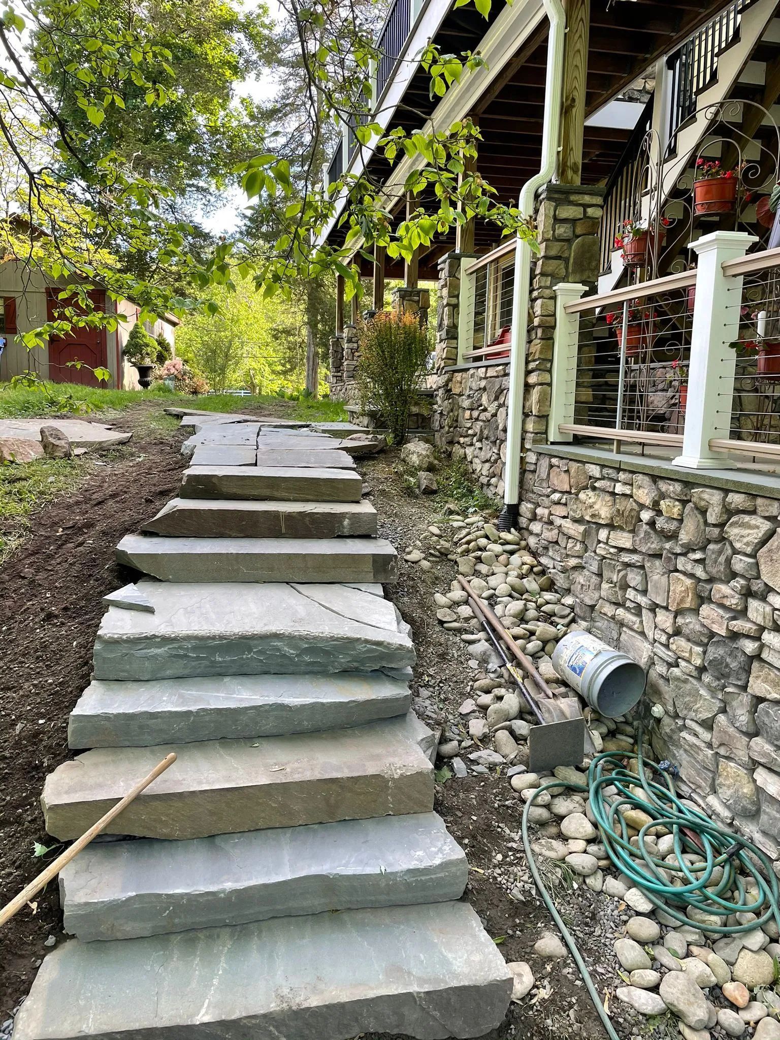 A stone walkway is being built in front of a house.