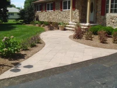 A stone house with a walkway leading to the front door