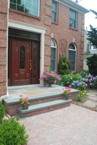 A brick house with flowers in front of it