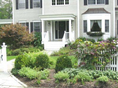 A house with a porch and a white picket fence