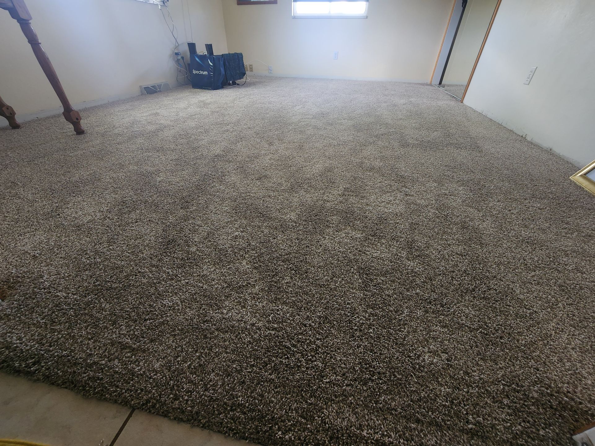 A large carpeted floor in a room with a chair.