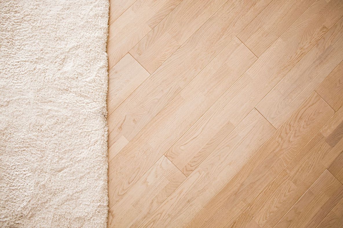 There is a rug next to a wooden floor.