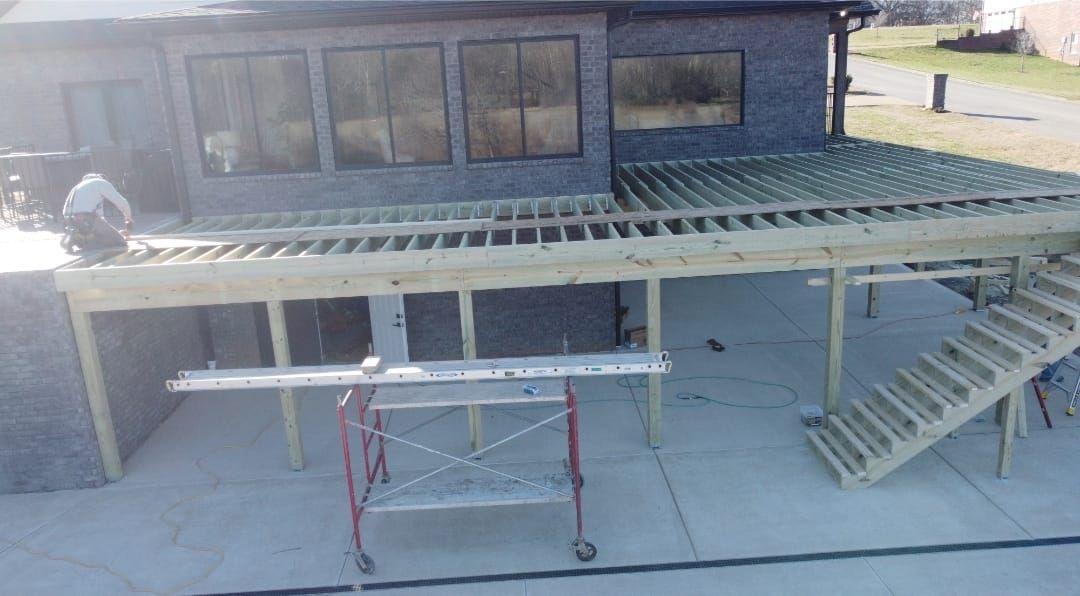 A wooden deck is being built in front of a house.