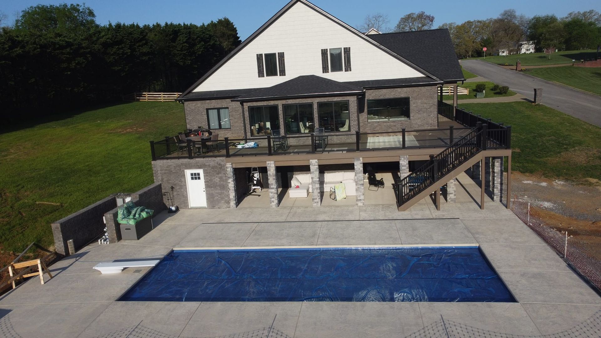 An aerial view of a house with a large swimming pool in front of it