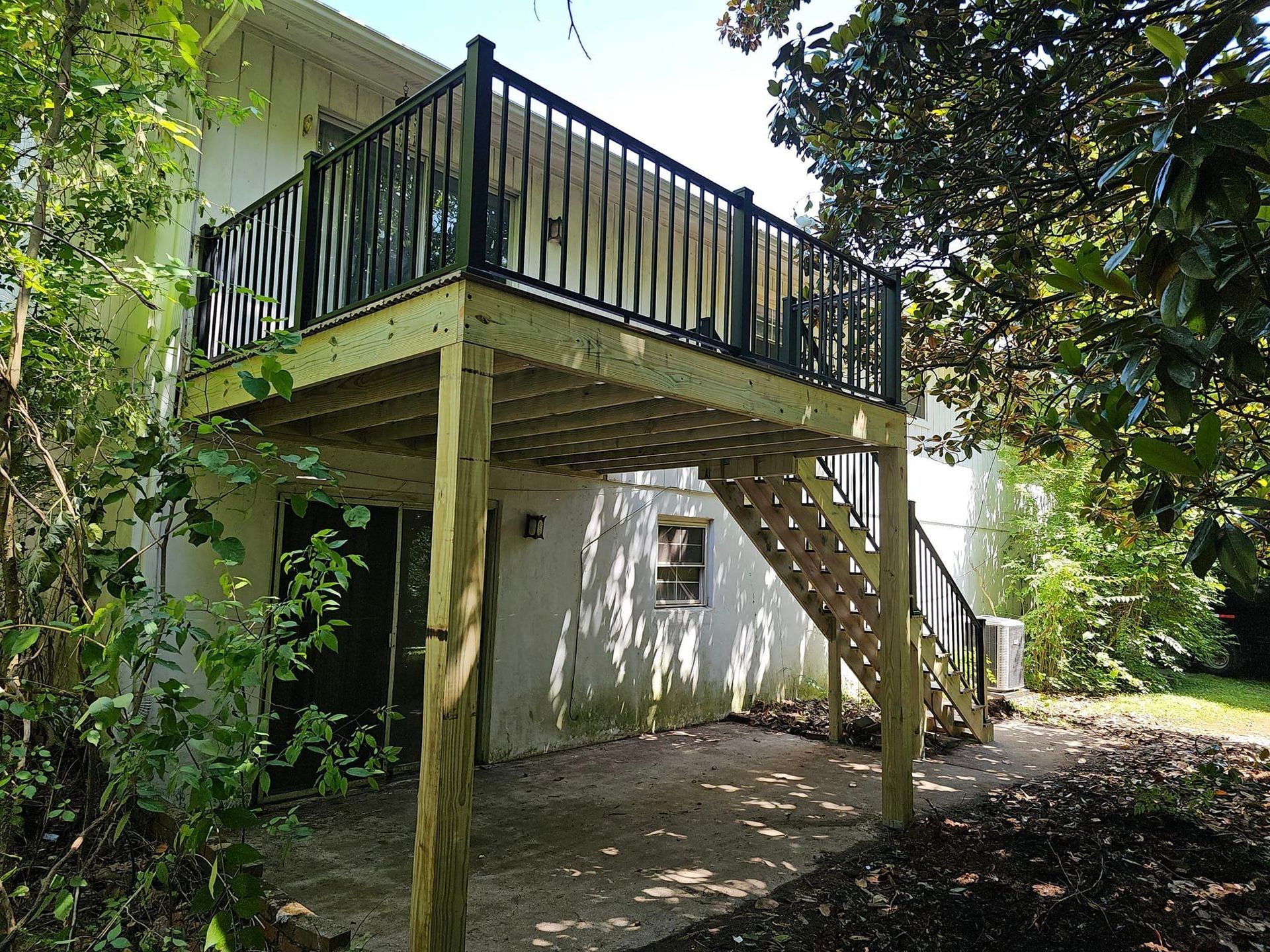 A house with a wooden deck and stairs leading up to it.