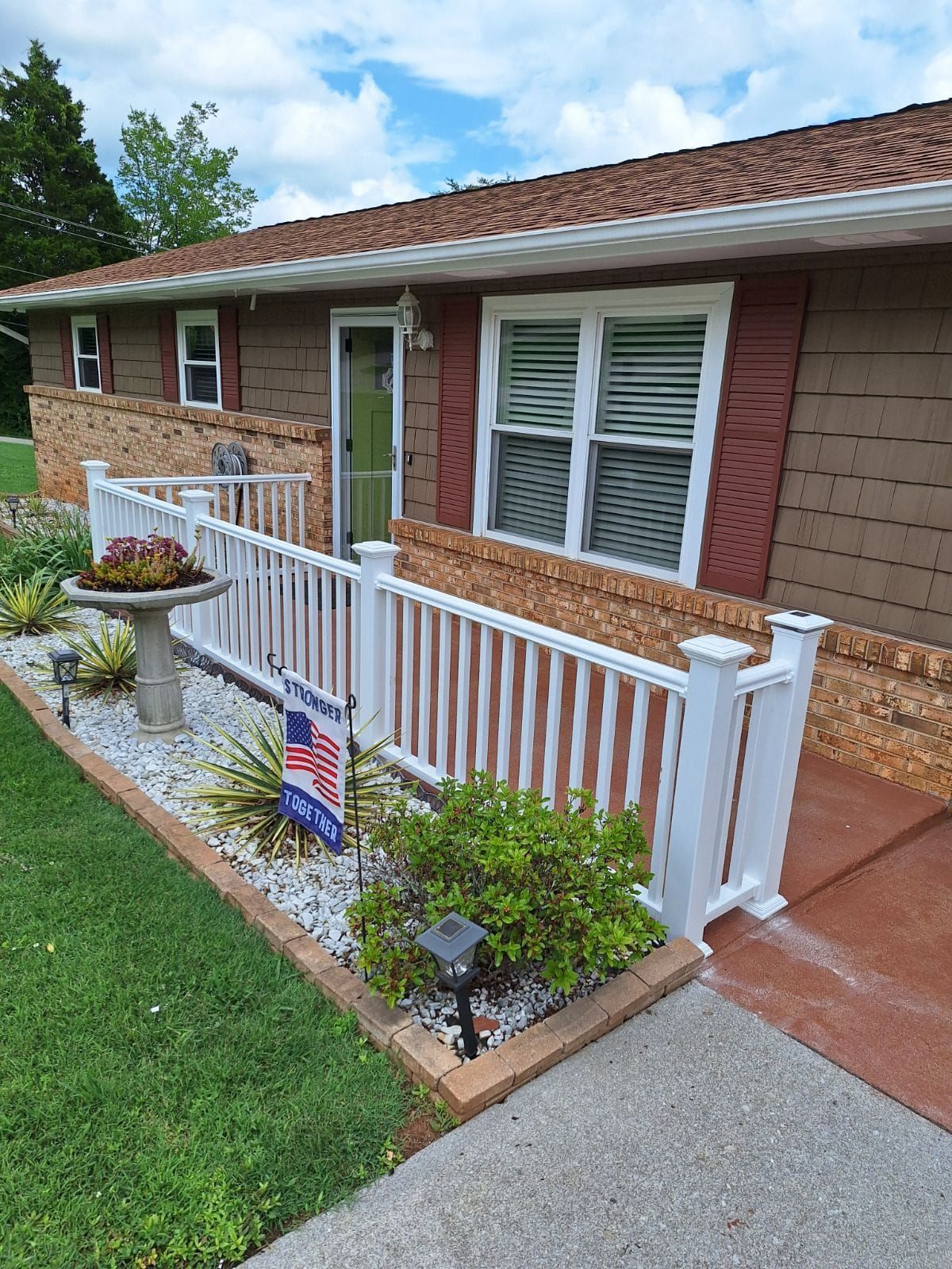 A house with a white fence and a flag in front of it.