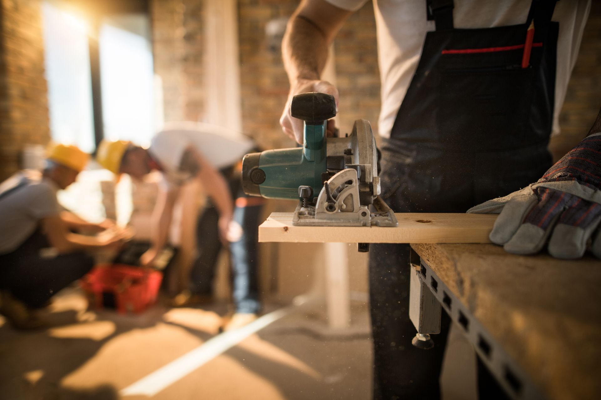 A man is using a circular saw to cut a piece of wood.
