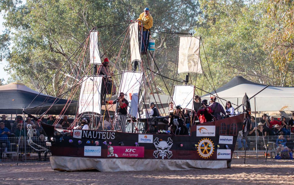 A man is standing on top of a stage in front of a crowd.