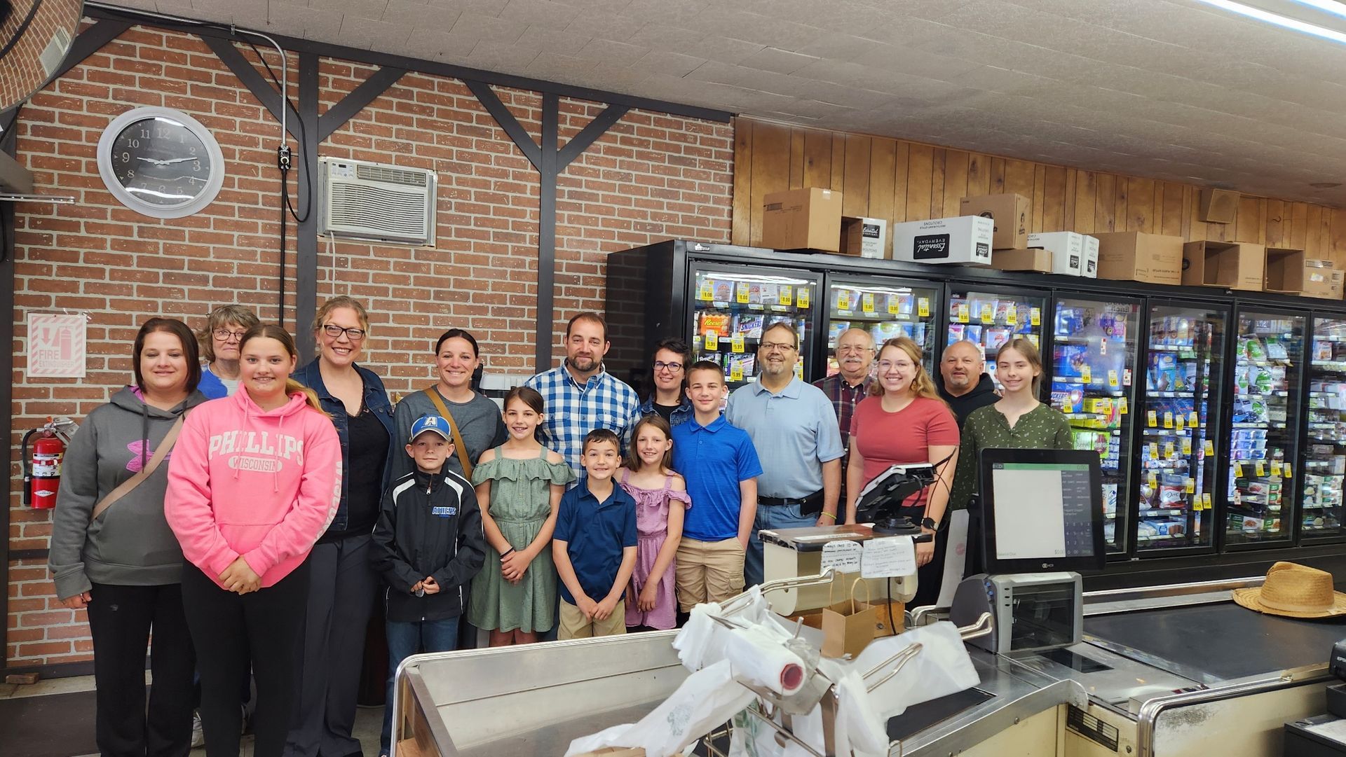 A group of people are posing for a picture in a grocery store.