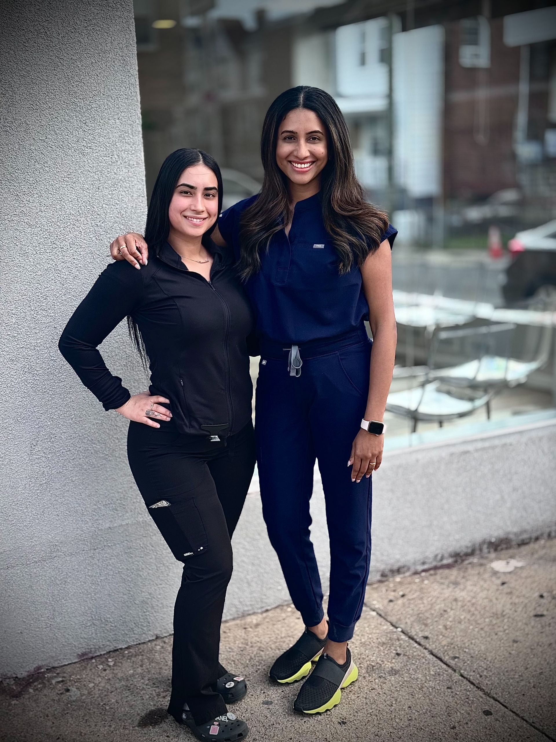 Two women standing in front of a 360 dental sign