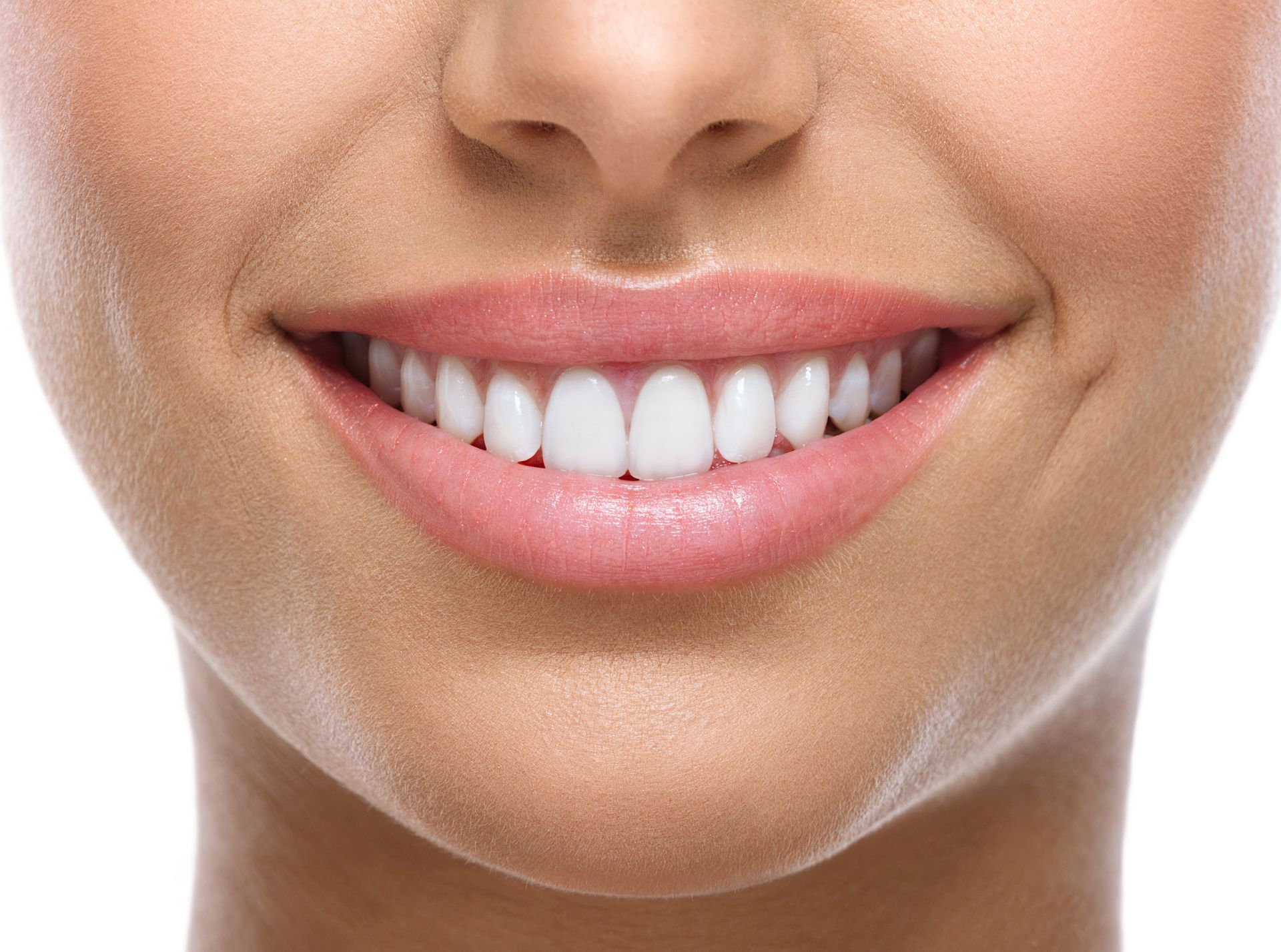 A woman is smiling while sitting in a dental chair.