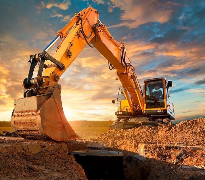 Uma escavadeira amarela está cavando um buraco no chão em um canteiro de obras.