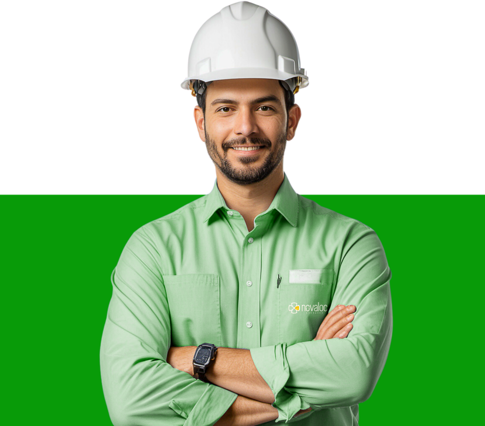 Um homem usando um capacete e uma camisa verde está de pé com os braços cruzados.