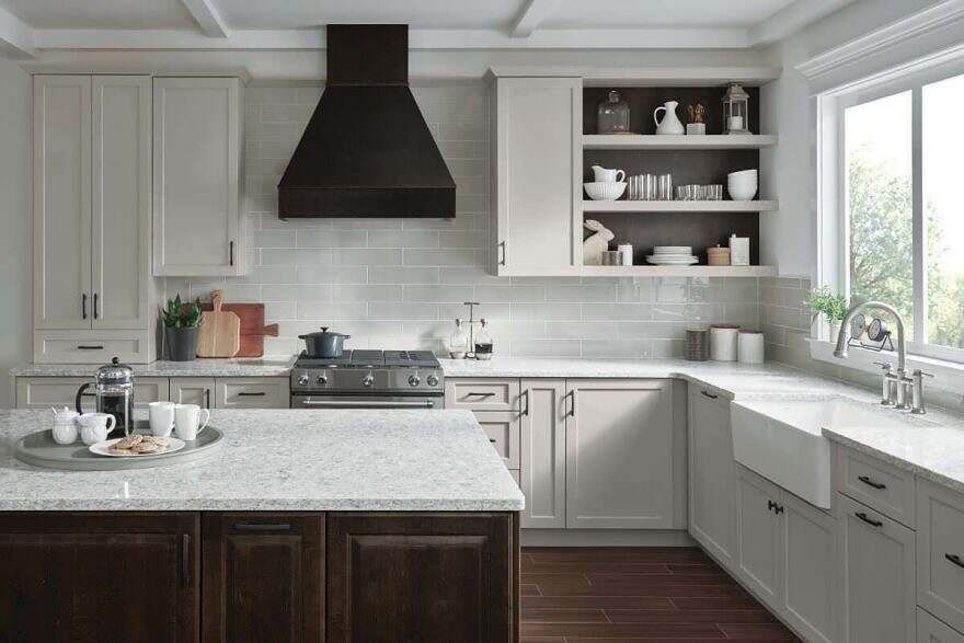 A kitchen with white cabinets , a stove , a sink and a window.