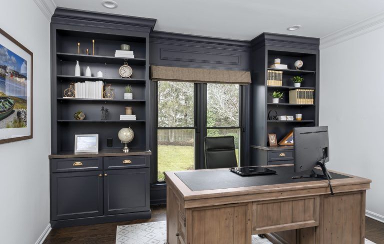 A home office with a desk , shelves , and a computer.