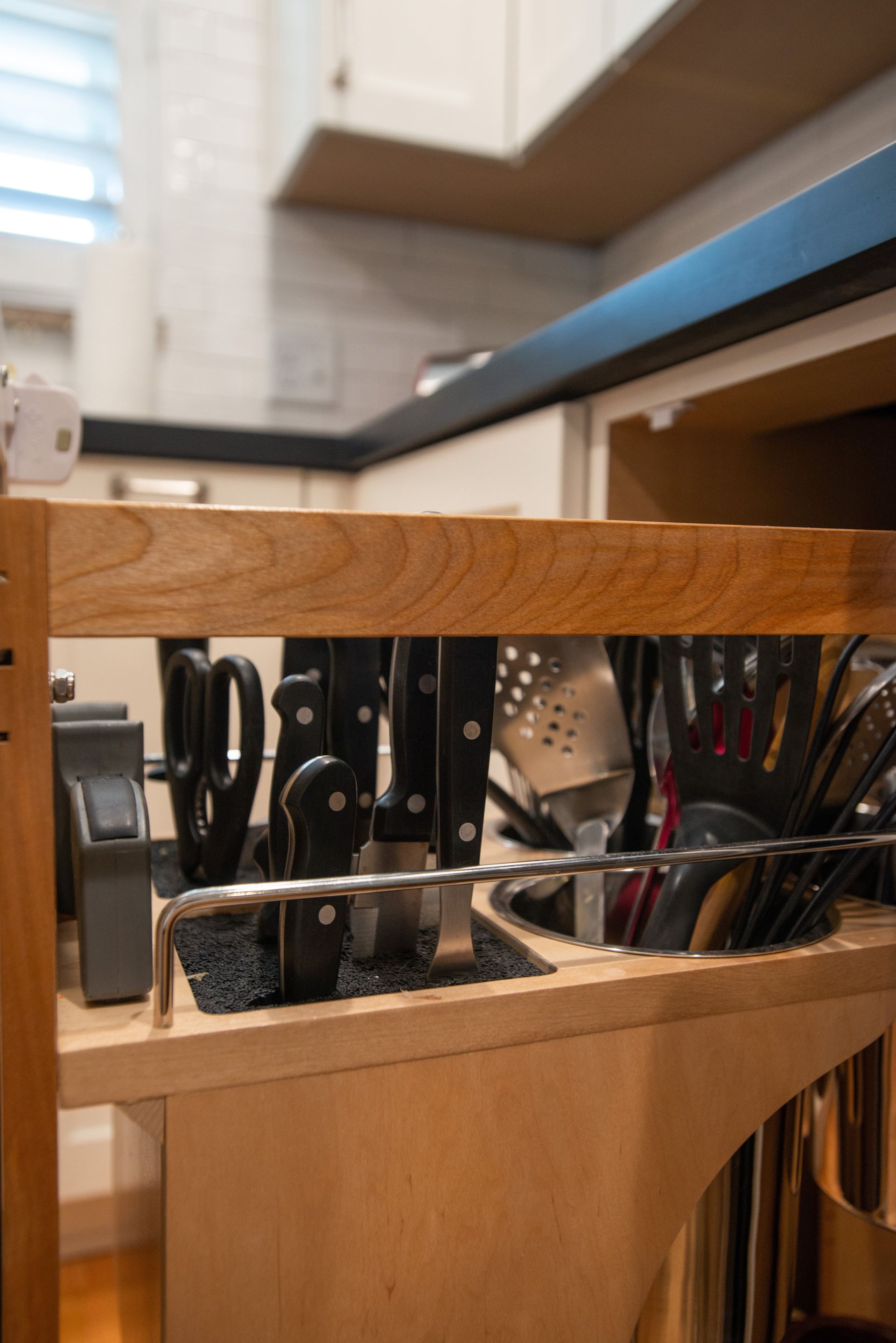 A kitchen drawer filled with knives and utensils.
