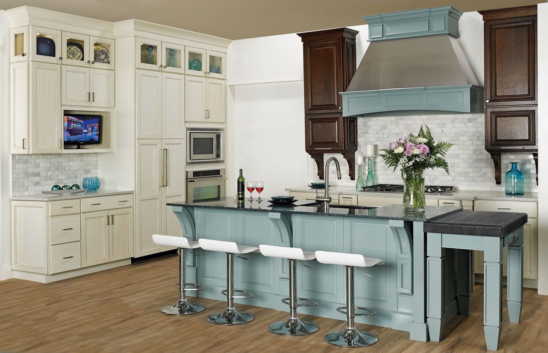 A kitchen with white cabinets and a blue island.