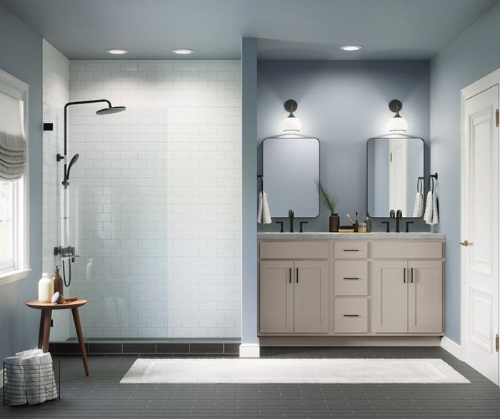 A bathroom with two sinks and a walk in shower.