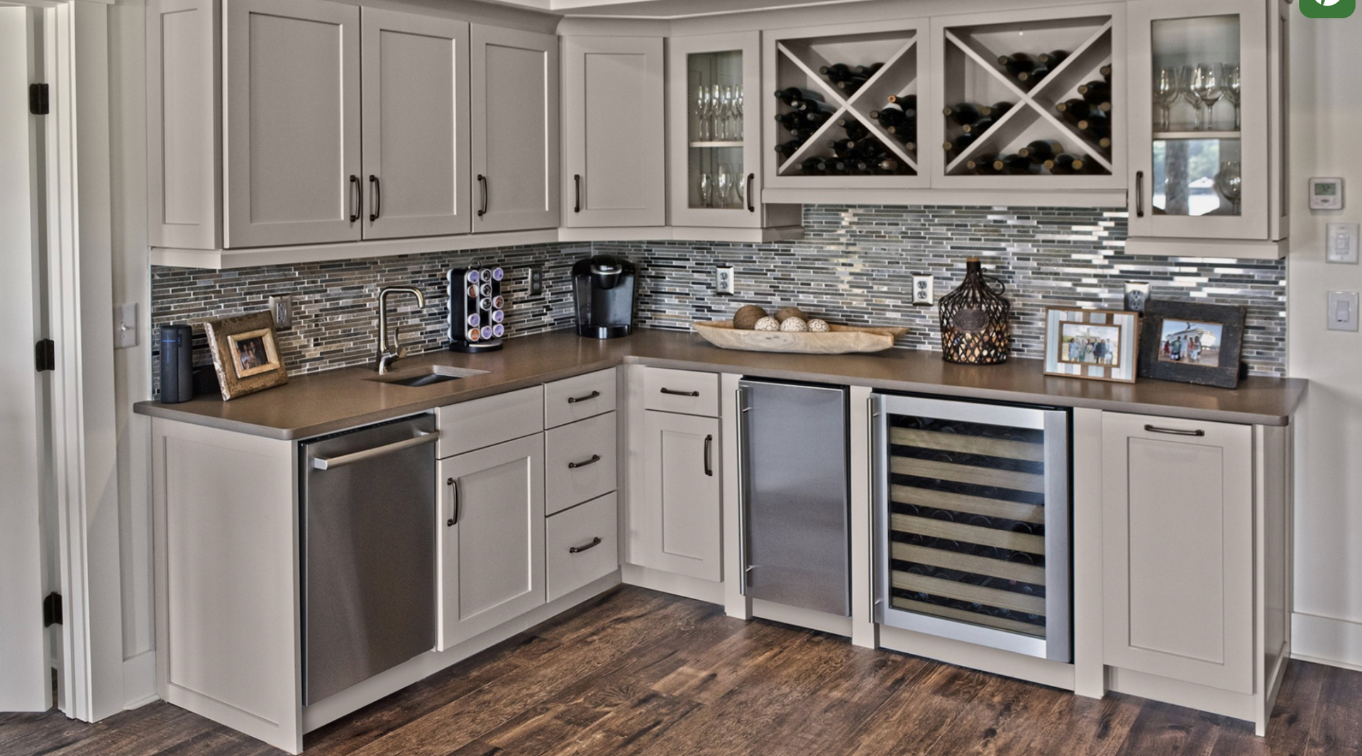 A kitchen with white cabinets and stainless steel appliances and a wine cooler.