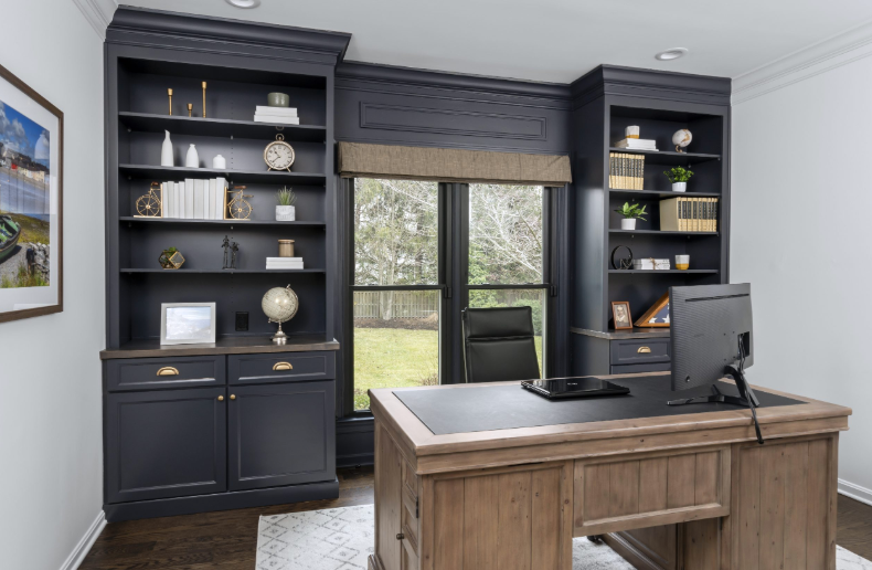 A home office with a desk , shelves , and a computer.