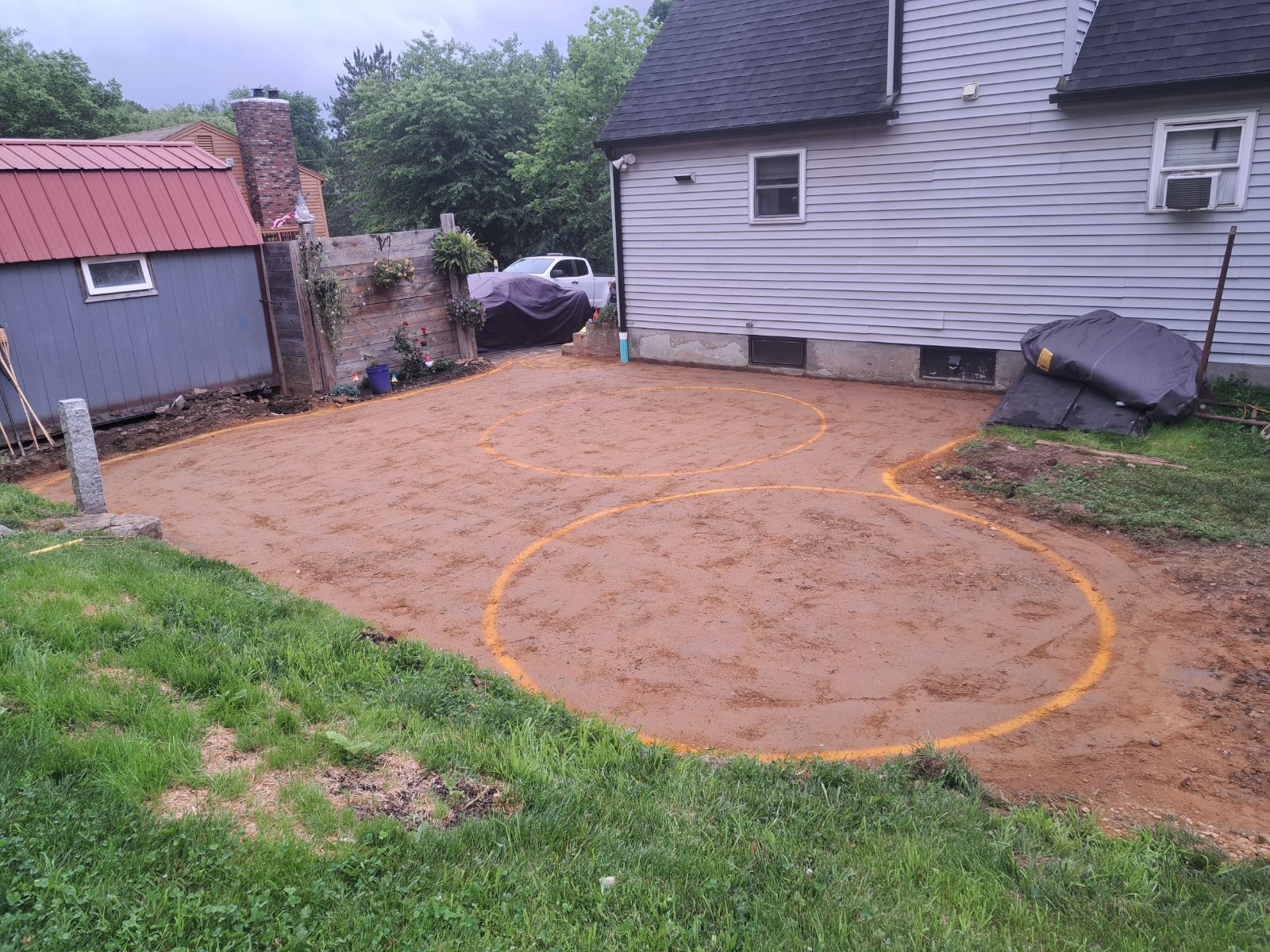 There is a circle in the middle of the dirt in front of a house.