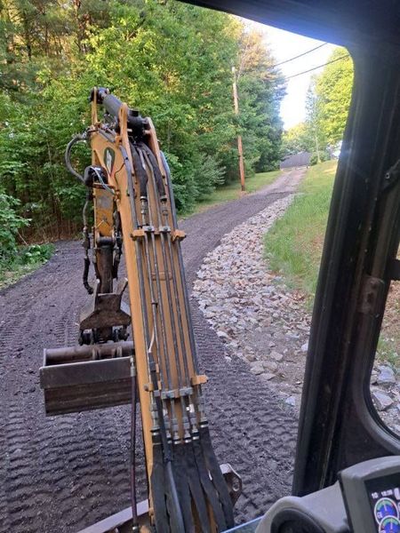 A construction vehicle is driving down a dirt road.