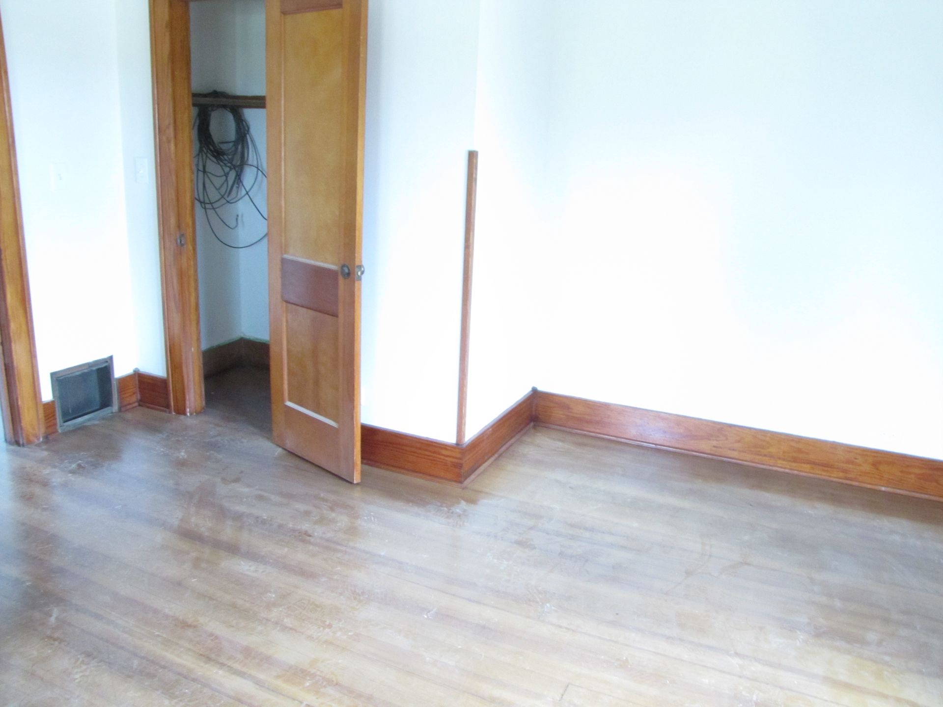An empty room with wooden floors and white walls
