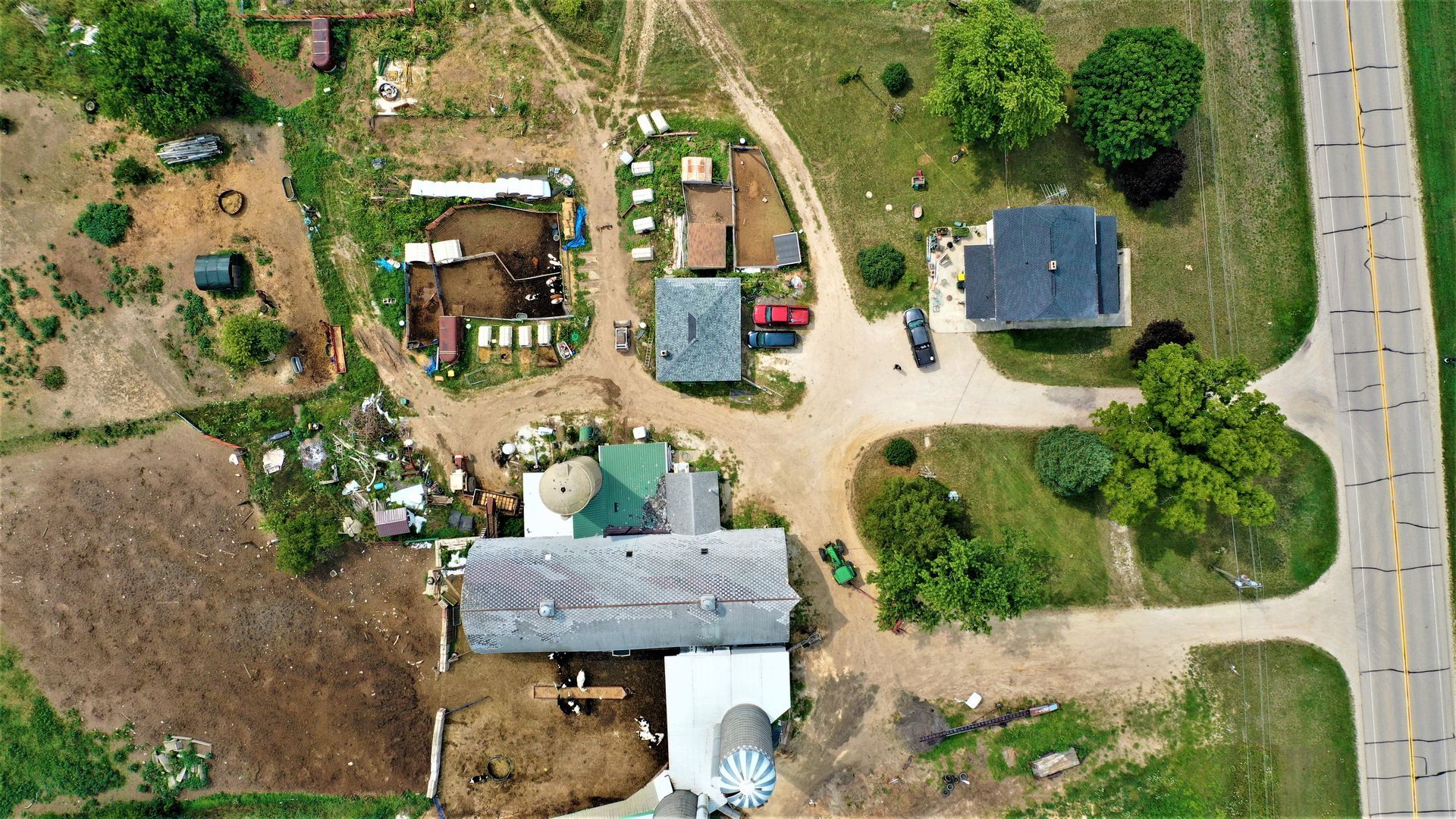 An aerial view of a farm with a lot of houses and trees.