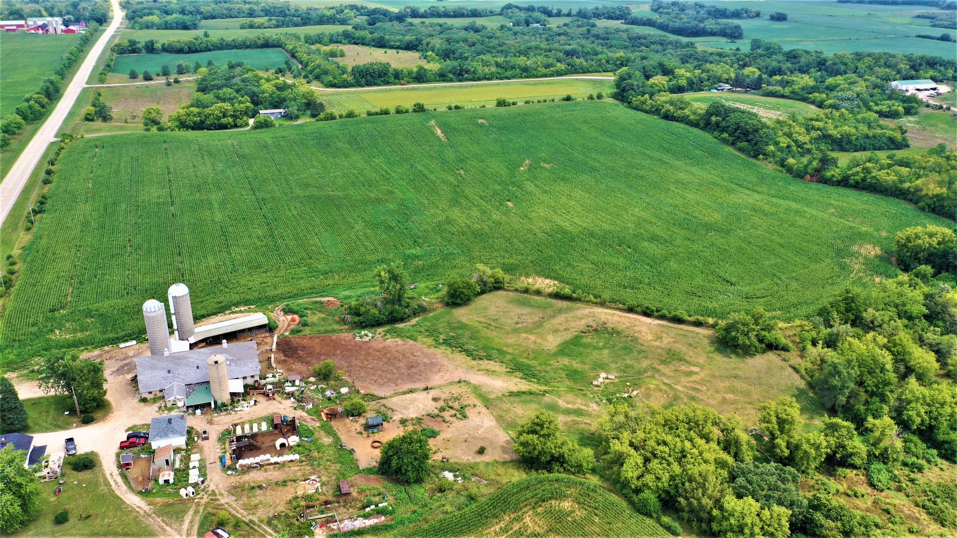 An aerial view of a farm surrounded by fields and trees.