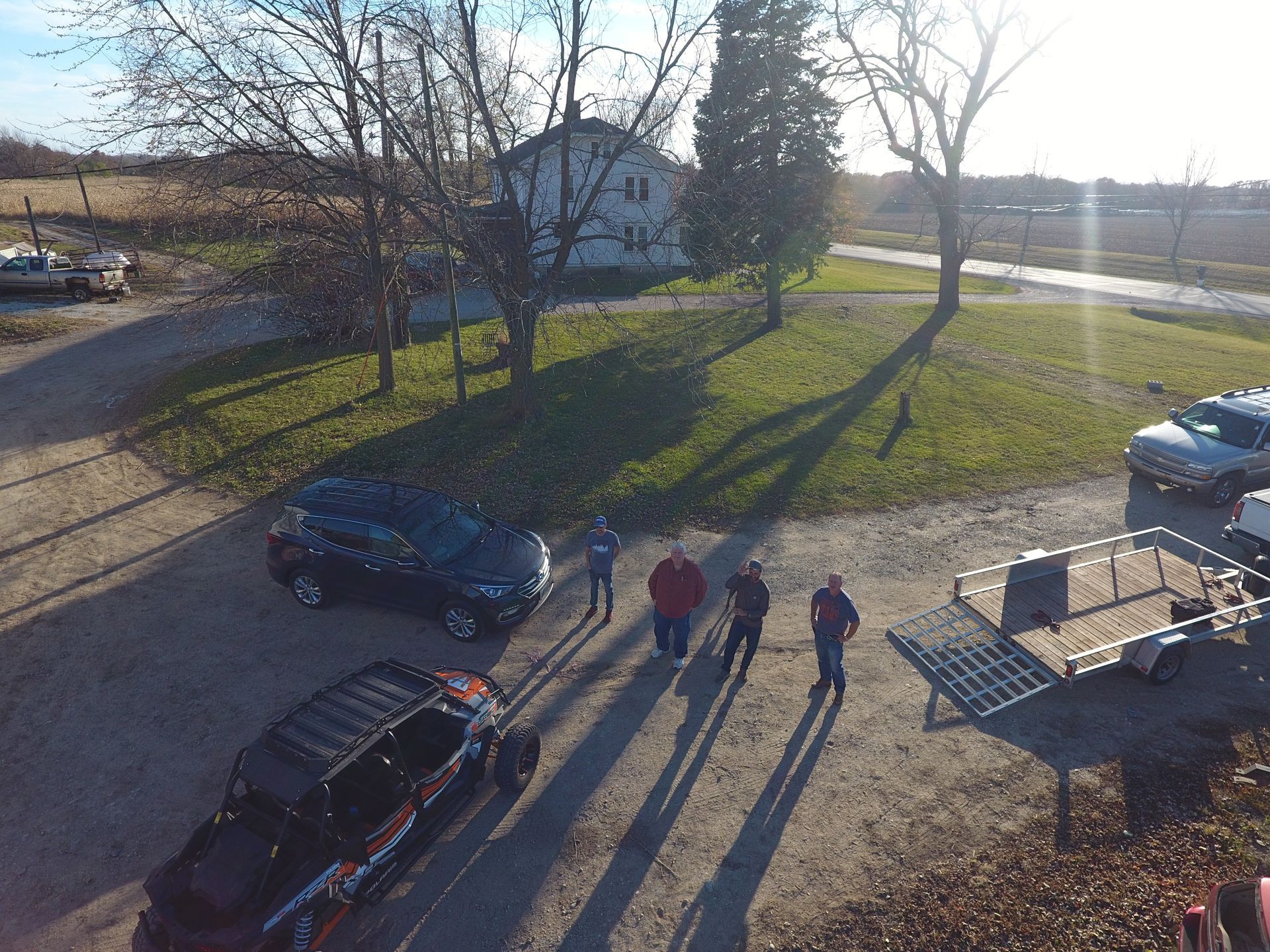 An aerial view of a group of people standing on a dirt road.