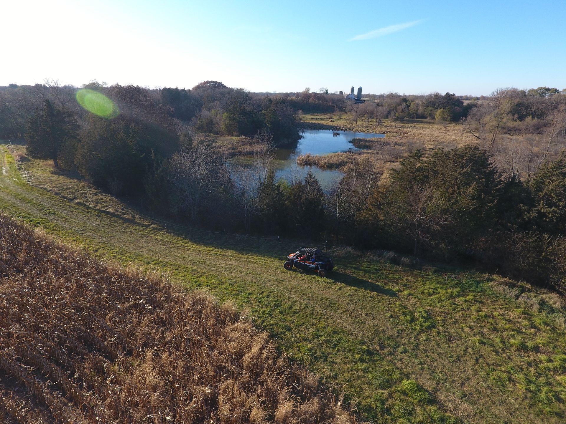 An aerial view of a atv parked on top of a grassy hill next to a body of water.
