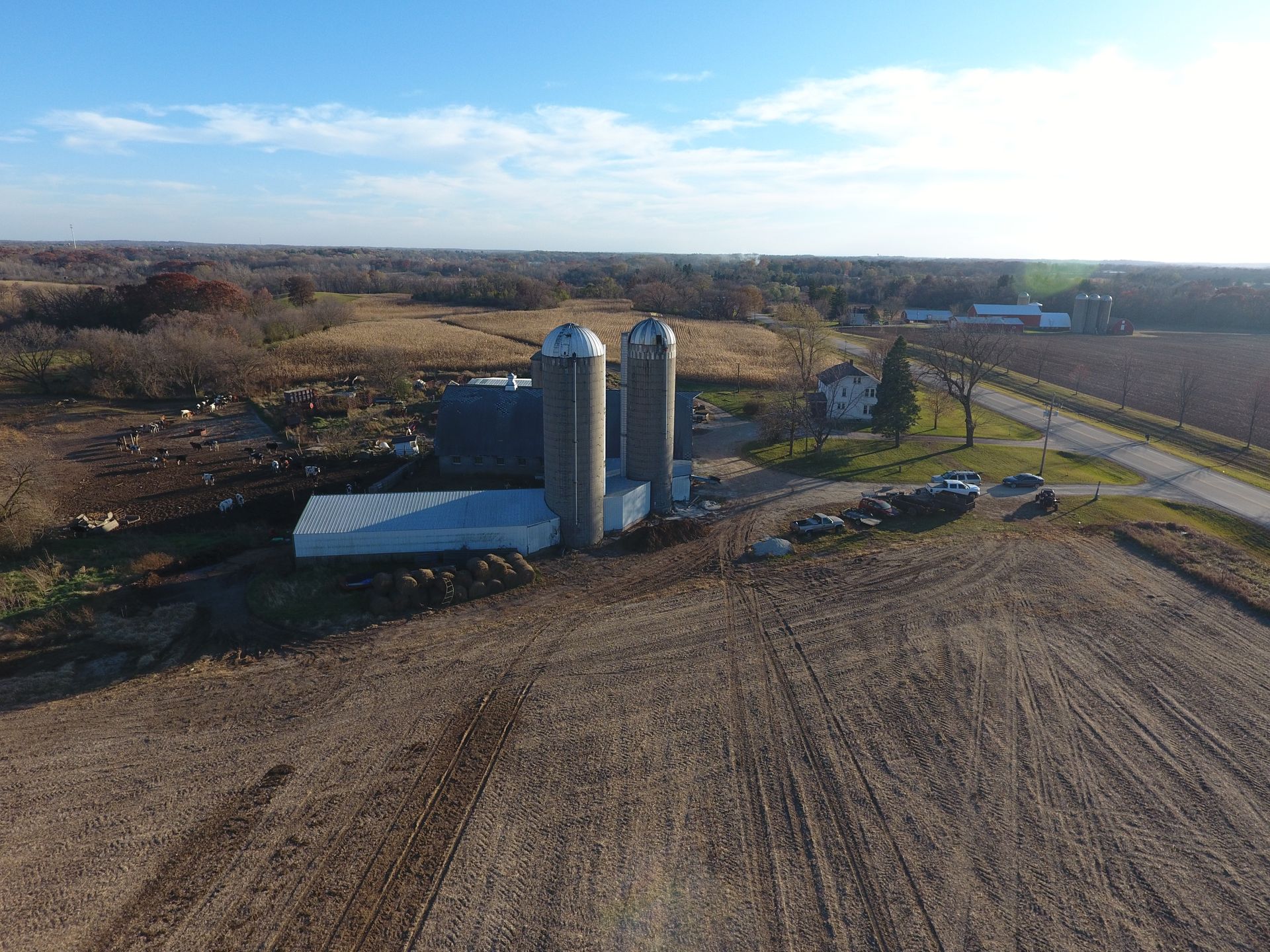 An aerial view of a farm with silos and a road.