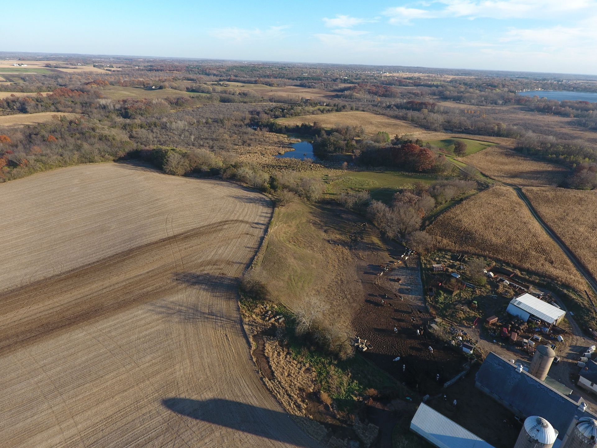 An aerial view of a farm surrounded by fields and trees.